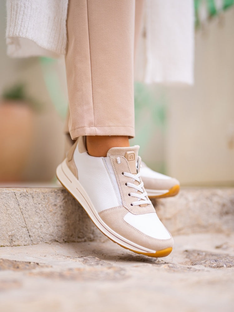White and sand ara sneakers on a stone step